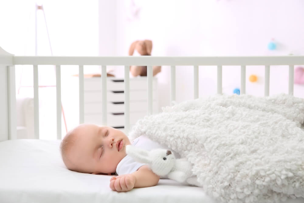 Adorable baby sleeping in cradle